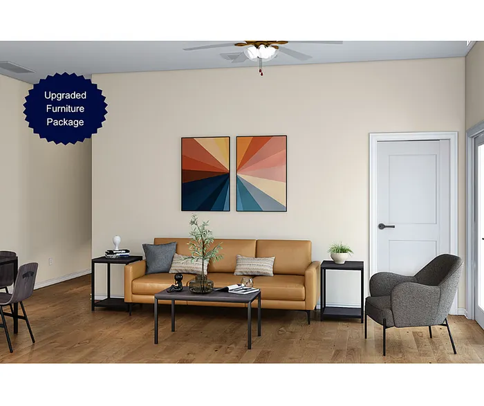 Modern living room with upgraded furniture package, featuring a stylish leather couch, contemporary armchair, and vibrant wall art.