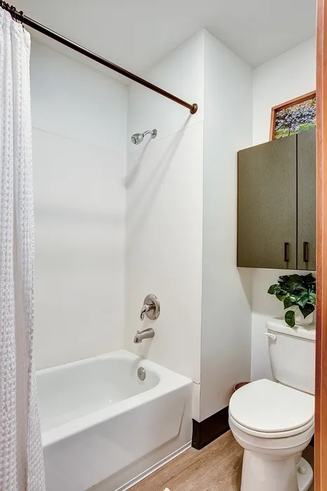 Bright and modern bathroom featuring a sleek bathtub, elegant fixtures, and a cozy atmosphere.