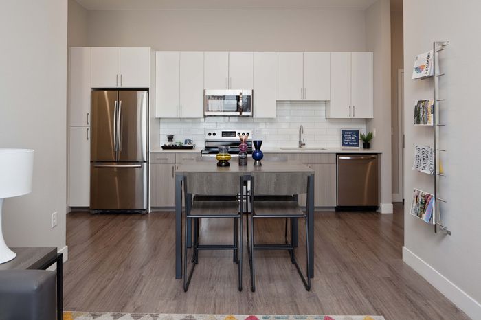 Modern kitchen design with sleek white cabinetry, stainless steel appliances, and wooden flooring.