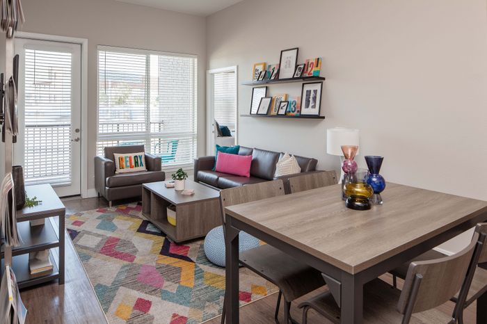 Bright and inviting living room with modern furniture, colorful rug, and decorative accents, perfectly blending comfort and style.
