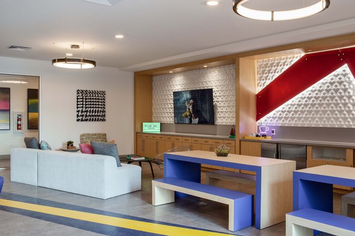 Chic and modern living space with stylish decor, featuring a cozy seating area, vibrant art pieces, and contemporary lighting. Perfect for relaxed gatherings.
