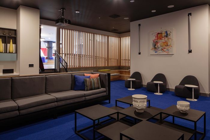 Chic lounge with modern seating, artistic decor, and vibrant blue accents, perfect for relaxation.