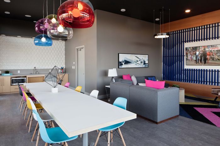 Modern and vibrant living space featuring colorful pendant lights, stylish seating area, and a sleek kitchen. Ideal for social gatherings and relaxation.