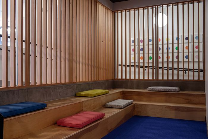 Chic and modern seating area with wooden paneling, vibrant cushions, and contemporary art accents.