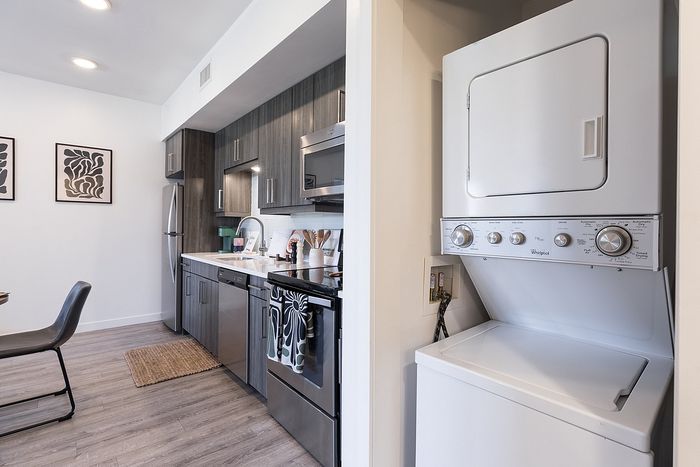 Modern kitchen with sleek cabinetry, stainless steel appliances, and in-unit washer and dryer.