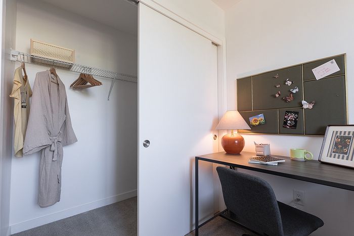 Chic apartment workspace with a cozy nook, featuring a sleek desk, modern chair, soft lighting, and ample storage, perfect for productivity and style.