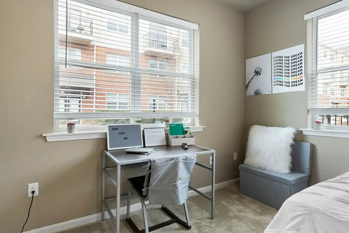 Bright and cozy bedroom workspace with modern desk and inspirational decor, perfect for productivity and relaxation.