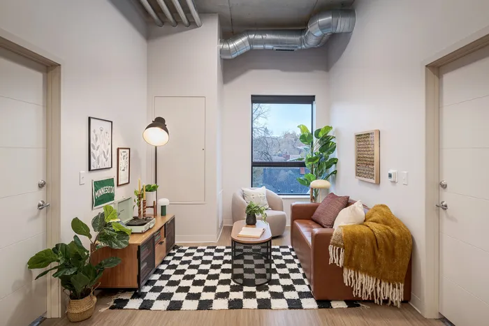 Chic apartment living room with modern decor, cozy seating, and stylish indoor plants. Natural light enhances the warm color palette and contemporary design.