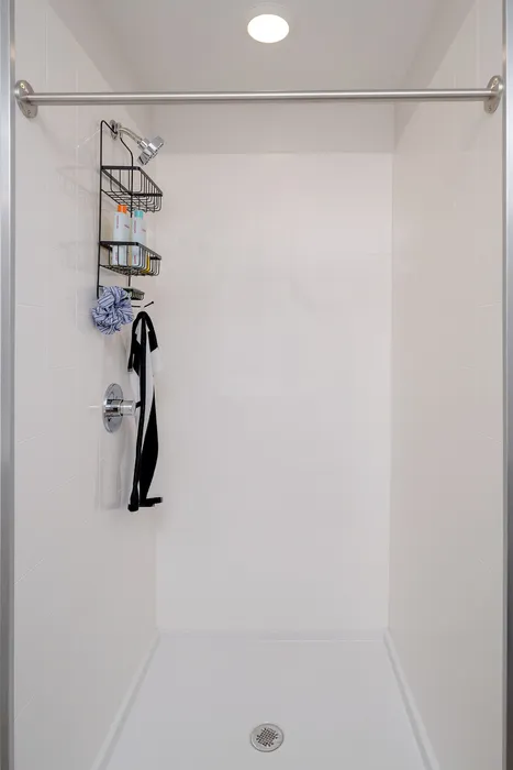 Elegant walk-in shower with modern fixtures and a sleek towel rack, perfect for a refreshing start to your day.