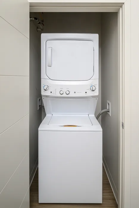 Compact laundry setup featuring a sleek stacked washer and dryer within a modern closet space.