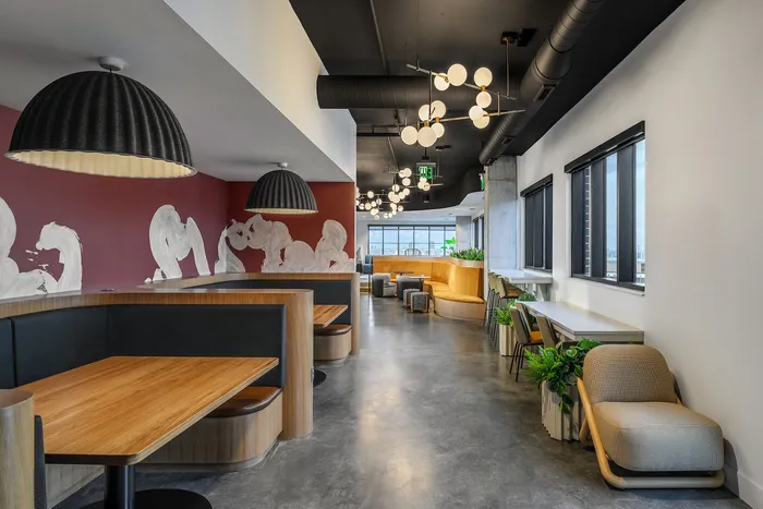 Chic modern lounge featuring stylish booth seating, artistic wall design, and contemporary lighting fixtures.