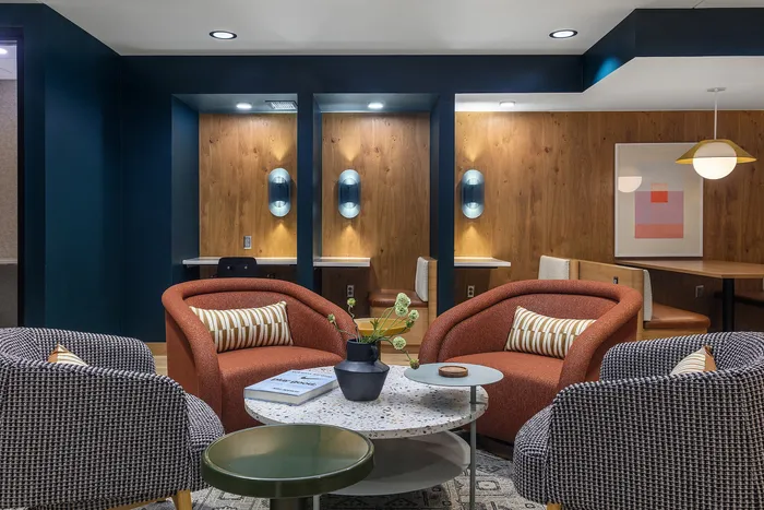 Modern lounge area featuring stylish armchairs, elegant lighting, and a chic coffee table with a vibrant plant display.