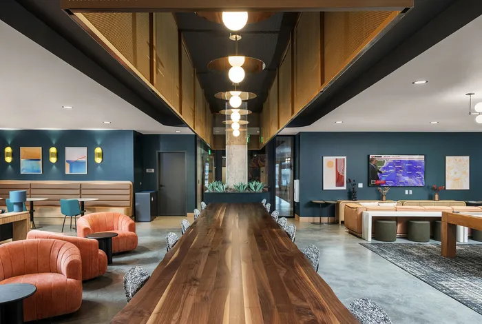 Modern communal space showcasing elegant wood table, cozy seating, and contemporary decor ideal for vibrant gatherings.