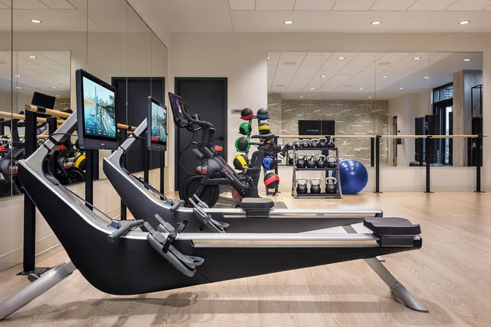 Modern fitness center featuring state-of-the-art equipment with sleek treadmills, colorful kettlebells, and dynamic space.