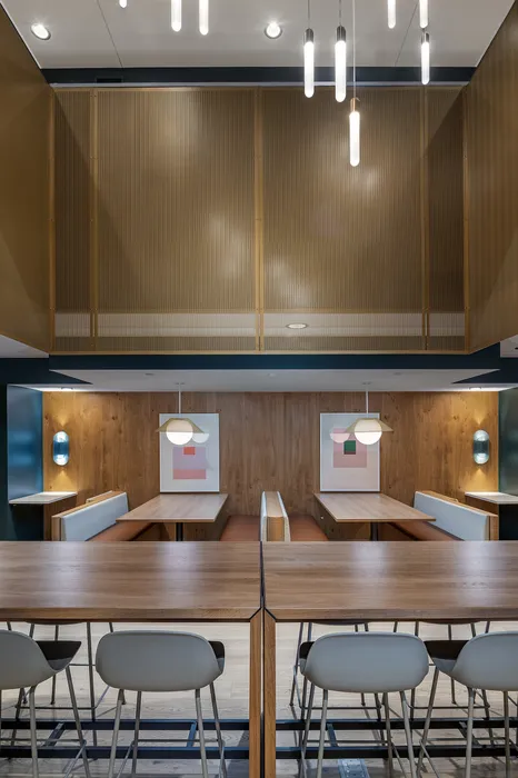 Chic and modern dining area with elegant wooden tables, stylish pendant lighting, and cozy booth seating for a perfect dining experience.