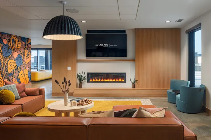 Chic living room with modern fireplace, vibrant mural, and leather seating for stylish comfort.