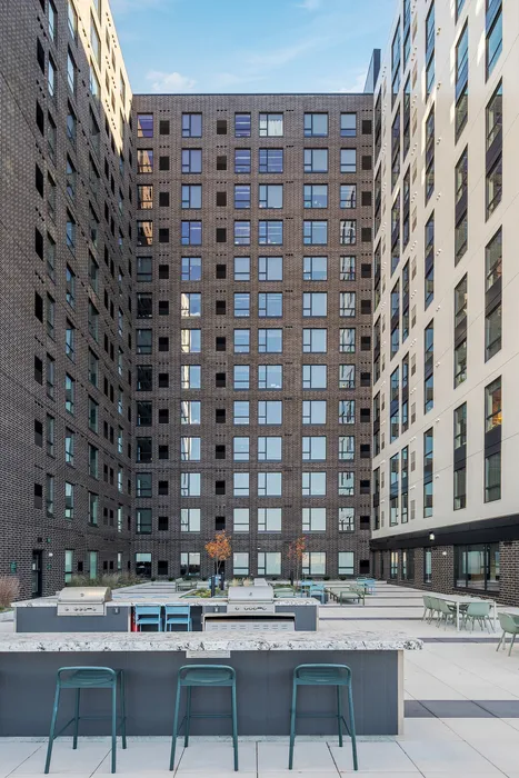 Elegant urban courtyard featuring modern outdoor seating, stylish countertops, and a stunning high-rise backdrop.