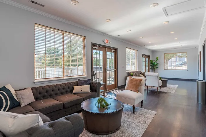 Inviting living room with elegant sofas, plush pillows, and abundant natural light through spacious windows.