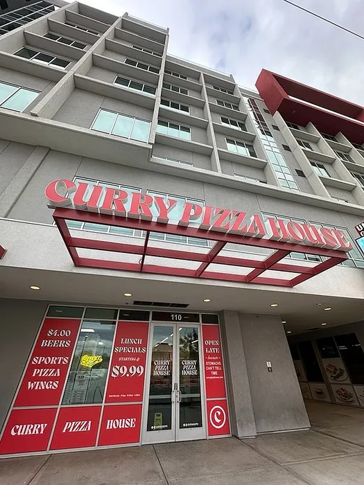 Modern exterior view of Curry Pizza House with vibrant red signage, enticing lunch specials at $9.99, and open late for ultimate convenience.