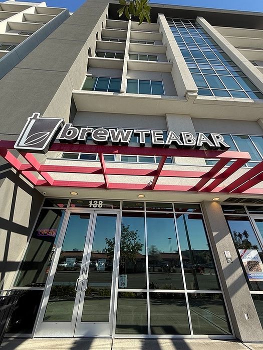 Chic modern apartment building with stylish brew tea bar signage, showcasing a vibrant and welcoming entrance.