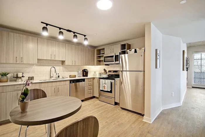 Modern kitchen with sleek stainless steel appliances, contemporary cabinetry, and stylish lighting, offering a bright and spacious culinary space.