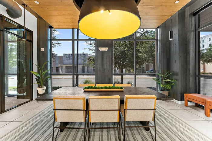 Chic modern dining area with large windows, stylish seating, and vibrant decor.