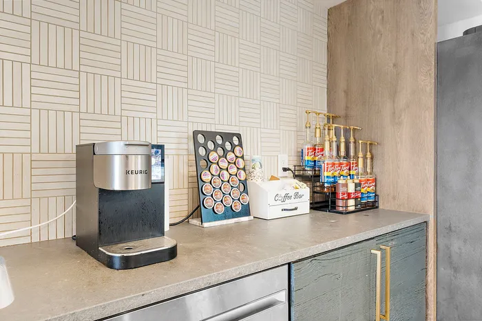Chic coffee bar setup featuring a modern Keurig machine, a variety of coffee pods, and a stylish selection of flavored syrups, perfect for a gourmet coffee experience.