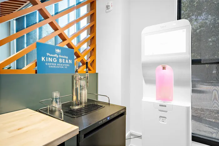 Inviting refreshment station featuring a modern beverage dispenser and King Bean Coffee sign, set in a stylish interior with natural light.