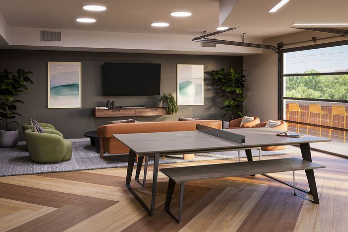 Chic modern living room with cozy seating, stylish TV setup, and expansive window view of lush greenery.