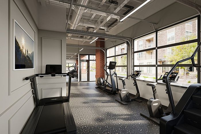 Bright, modern gym with state-of-the-art equipment and large windows offering a scenic view.