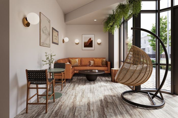 Bright and inviting living room with modern decor, featuring a plush leather sofa, chic hanging chair, and large windows with lush greenery.