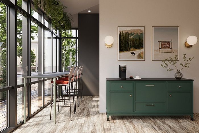 Elegant dining area with floor-to-ceiling windows, stylish bar seating, and a chic green sideboard adorned with art and modern lighting.