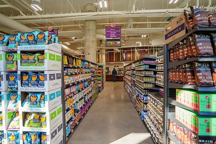 Colorful grocery store aisle with a variety of snack products neatly displayed on shelves.