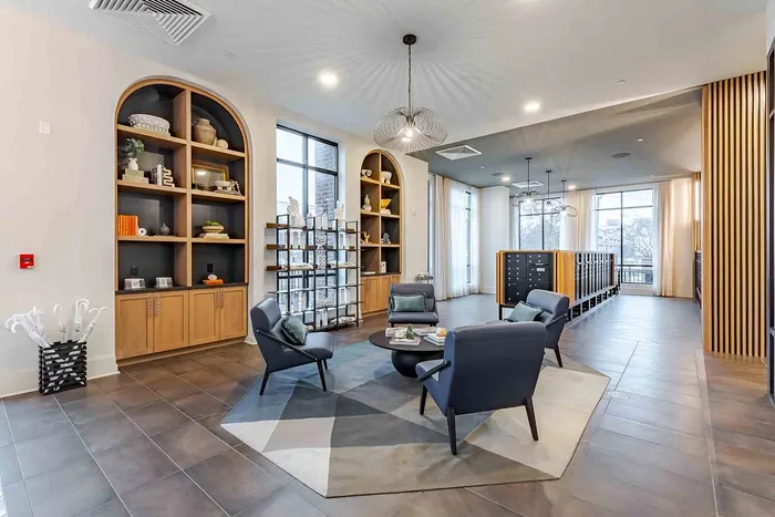 Luxurious apartment lobby featuring elegant seating area, modern light fixtures, and stylish built-in shelving.