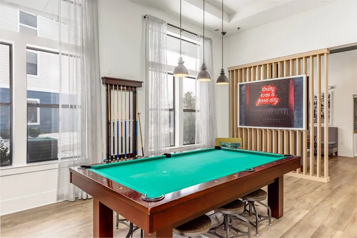 A pool table with chairs in the clubhouse at Domain at Town Centre apartments in Morgantown, WV