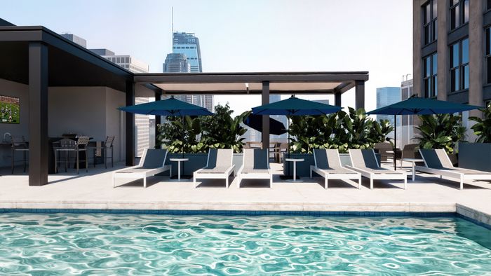 Rendering of a luxurious rooftop pool area featuring sleek lounge chairs, vibrant green plants, and shaded seating, with a stunning city skyline backdrop.