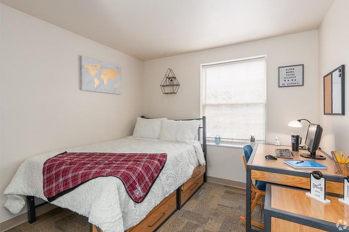 Cozy and inviting bedroom with a comfortable bed, bright workspace, and modern decor.
