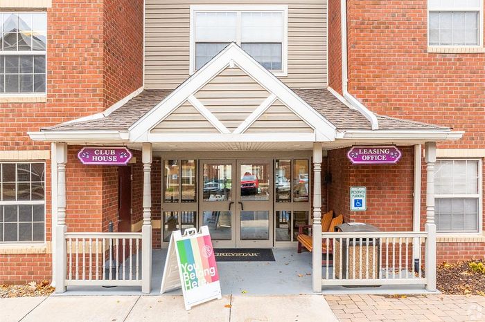 Inviting clubhouse entrance with leasing office, showcasing charming brick exterior and welcoming atmosphere.