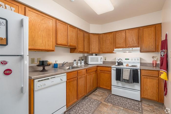 Charming kitchen with warm wooden cabinets, modern appliances, and a cozy layout creating a welcoming culinary space.