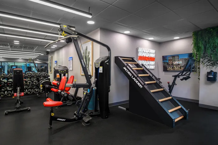 Modern fitness center featuring advanced equipment like weights, a Hoist machine, a Jacobs Ladder, and a stationary bike, ideal for an invigorating workout.