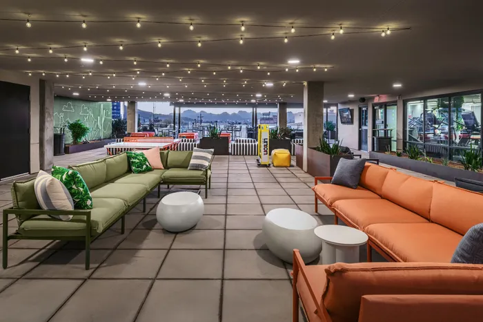 Chic outdoor lounge with colorful seating, ambient string lights, and stunning mountain views.