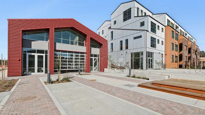 Modern architectural complex featuring vibrant red and sleek white structures with expansive windows and stylish entryways.