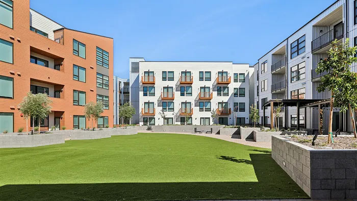 Charming modern apartment complex with stylish architecture, vibrant courtyard, and inviting green spaces perfect for relaxation.