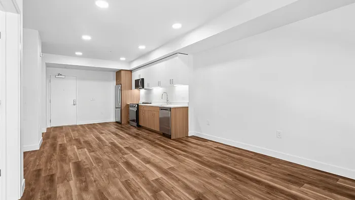 Modern open-concept kitchen with sleek appliances and elegant hardwood flooring, perfect for stylish living.