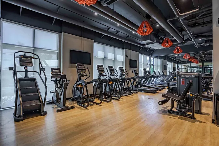 Modern fitness center with state-of-the-art treadmills and exercise equipment on sleek wooden flooring.