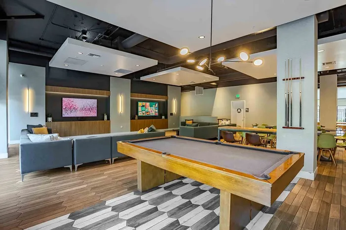 Chic entertainment lounge with modern pool table, plush seating, and vibrant decor, perfect for social gatherings.