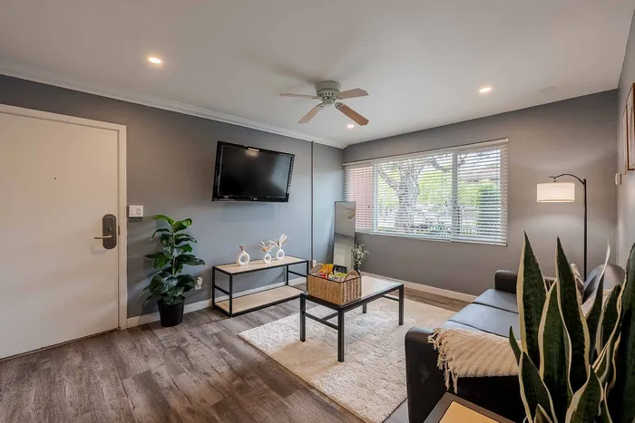 Inviting living room with modern decor, cozy seating, and natural light streaming through large windows.