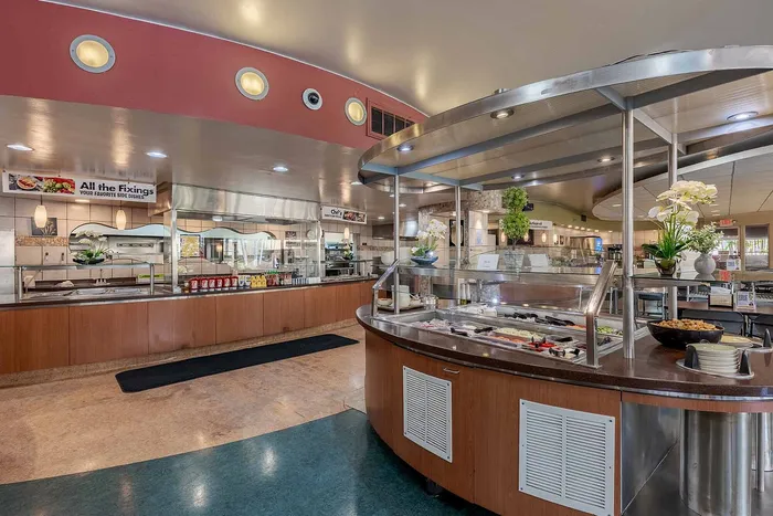 Inviting cafeteria interior showcasing a modern serving area with fresh salad options, elegant decor, and ample lighting.