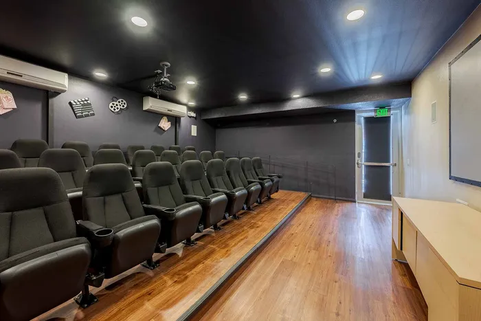 Luxurious private theater room with comfortable seating, ambient lighting, and sleek wooden flooring, perfect for entertainment enthusiasts.
