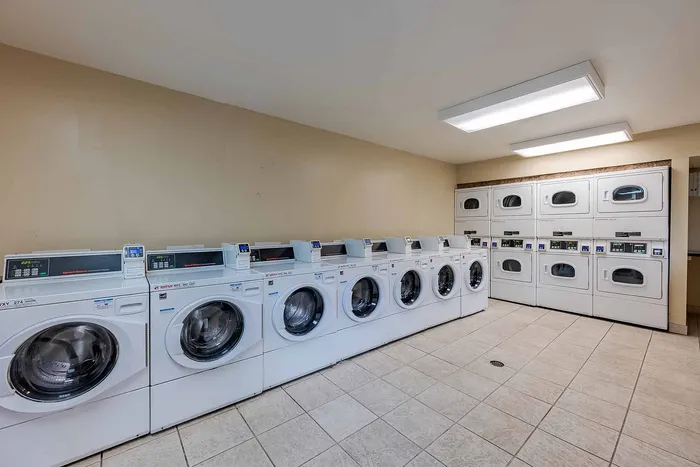 Modern and spacious laundry room featuring multiple washing machines and dryers, offering convenience and efficiency.